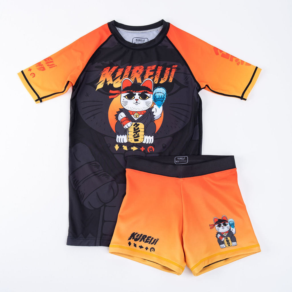 Kureiji Womens Combat Shorts Neko Fury Sunrise, front flat lay paired with matching rash guard, orange-to-yellow gradient
